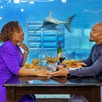 Couple dine amongst the sharks at the world famous Cargo hold restaurant in Durban South Africa as featured on the durbanvibe.co.za what's on in durban and Durban tourist information website
