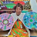 Artisan holding Plates at the African Art Centre in Durban South Africa as featured on the durbanvibe.co.za what's on in Durban and Durban attractions tourist information website